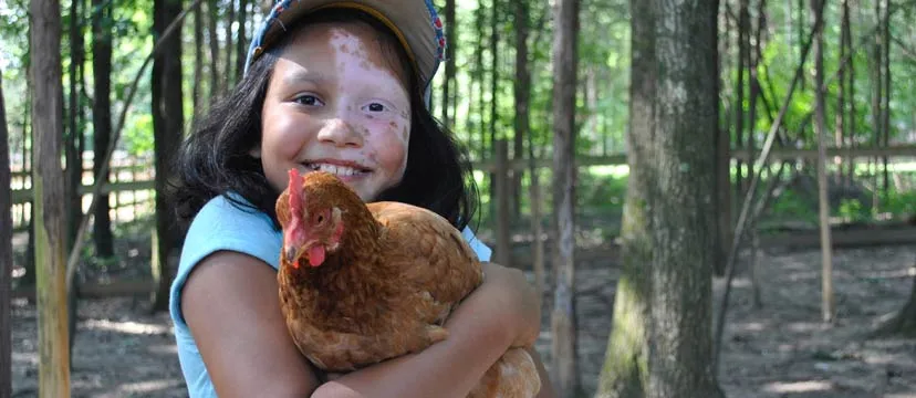 Girl holding farm chicken