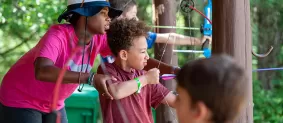 Girl shows boy how to shoot arrows