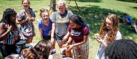 Widji campers learn how to cook outside at a picnic table.